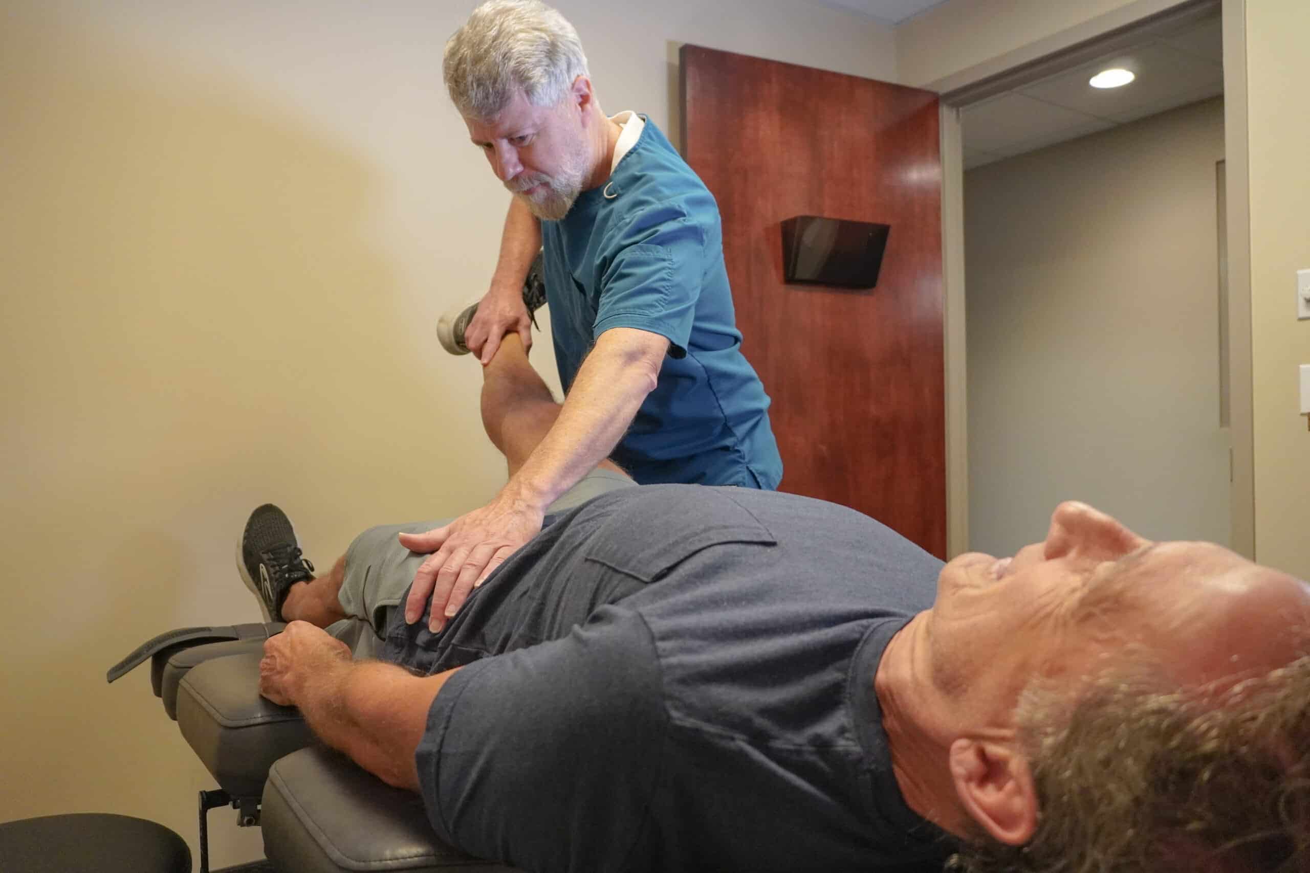 Total Health physical therapist performing manual spinal adjustment for pain relief.
